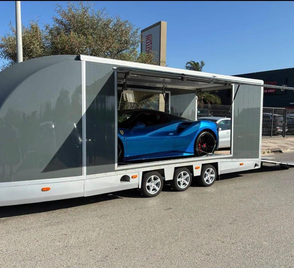 Ferrari azul dentro del remolque cerrado de transporte premium